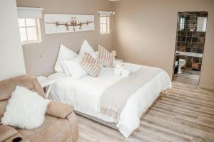 布隆方丹Private luxurious 3 bedroom complete house的卧室配有带枕头和沙发的白色床。