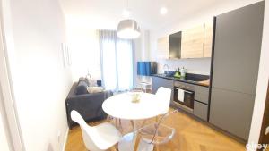巴里Seven Seas Luxury Apartments - Bari San Girolamo的一间厨房,里面配有白色的桌子和椅子