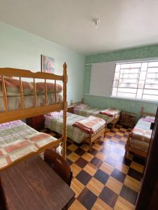 拉热斯Pousada Irmãs Franciscanas的一间卧室设有四张双层床和一张可调节的地板。