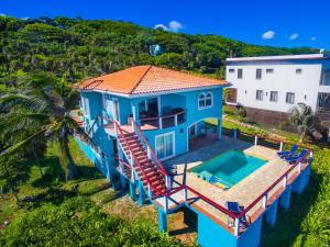 西湾Oceanfront Coral View Home的蓝色房子的空中景观,设有一个游泳池