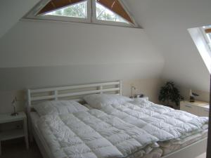 青斯特Zingst-3-Zi-Ferienwohnung-DEICHIDYLL-Strandresidenz-Godeke-Michels的卧室内的一张白色床,设有窗户
