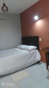 GuarabiraPousada Mariza的一间卧室配有一张带白色床单的大床