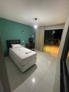 GuarabiraPousada Mariza的卧室配有白色的床和绿色的墙壁