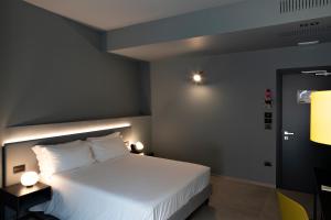 莱切Arryvo Hotel的卧室配有一张白色大床和两盏灯。
