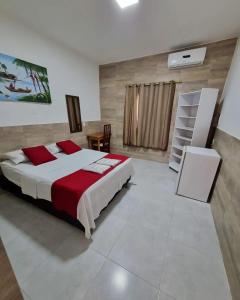 阿拉卡茹阿瓜多拉达斯旅馆的一间卧室配有一张带红白毯子的床