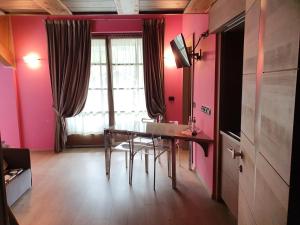 阿帕里卡塞雷内拉住宿酒店的用餐室设有粉红色的墙壁和桌椅