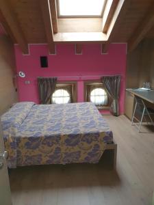 阿帕里卡塞雷内拉住宿酒店的一间卧室配有一张床和粉红色的墙壁