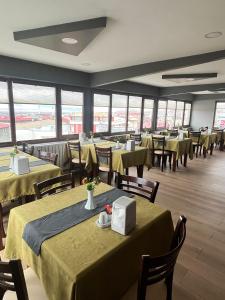 埃尔祖鲁姆ÇAĞ OTEL的餐厅设有绿色桌椅和窗户。
