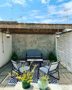 莱切beddhra mia的庭院配有两把椅子和一张桌子,还有一些植物
