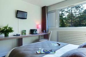 杜尔当贝拉姆布拉乐诺尔蒙特度假酒店的配有一张床、一张书桌和一扇窗户的酒店客房