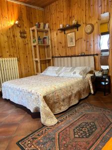 廖卢纳托B&B Il Nido的卧室配有一张床铺,位于带木墙的房间内