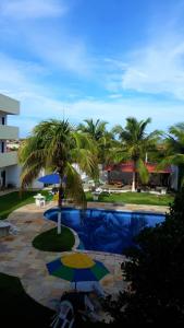 阿奎拉兹Hotel Pousada Summer Way的一个带棕榈树和遮阳伞的游泳池