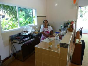 考索Khao Sok Jasmine Garden Resort - SHA Certified的站在厨房准备食物的妇女