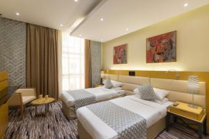 麦加Qasr Al Sahab Hotel Makkah的酒店客房,设有两张床和一张沙发