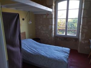 圣耐克森A la Gare的一间卧室设有一张床和一个窗口
