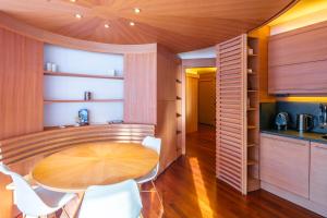 塞斯特雷Terrazza su Sestriere Lux的厨房以及带木桌和椅子的用餐室。