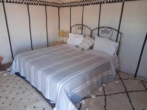 MhamidCouleur du désert的卧室配有一张带白色床单和枕头的大床。