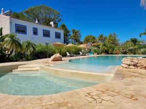阿尔戈什Superbe villa avec piscine en algarve的一座带房子的庭院内的游泳池