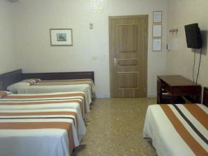 罗马桑皮耶特罗酒店的一间酒店客房,设有三张床和一扇门