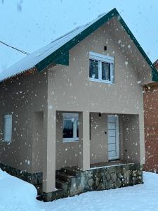 科拉欣Apartman Kruna的院子里的雪覆盖的房子
