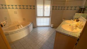 Ollon传统住宿加早餐旅馆的浴室配有两个盥洗盆和浴缸。