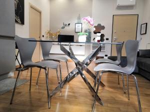 佩斯卡拉Hakuna Matata B&B的一间设有玻璃桌和四把椅子的用餐室