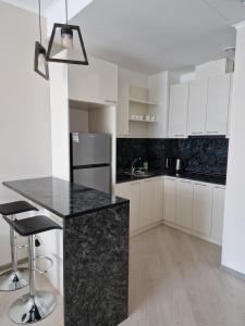 萨克德佐尔镇Alvina apartment Tsaghkadzor的厨房配有白色橱柜和黑色台面