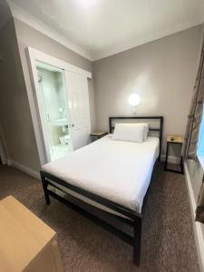 伦敦贵族酒店的卧室设有一张白色大床和一扇窗户。