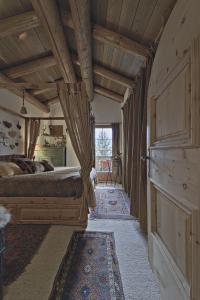 楚奥茨Chesa Brunzigna - Zuoz的一间卧室设有一张大床和木制天花板