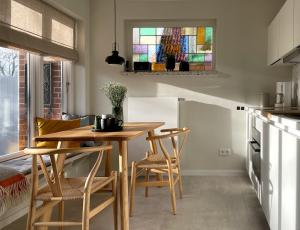威克奥夫弗尔Ferienwohnung Klaus的厨房配有桌椅和彩色玻璃窗。