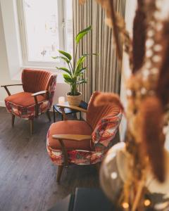 托伦Hotel restaurant SAM的客厅配有两把椅子和植物