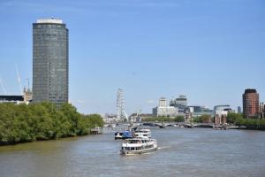 伦敦River Panorama Central London 2 bedroom New Development的两艘船在河上,以城市为背景