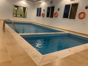 麦加فيلا المنزل的游泳池位于铺有瓷砖地板的客房内