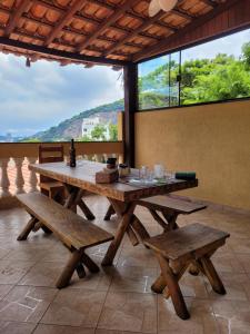 里约热内卢Santo Mirante Hostel的一张带长凳和大窗户的野餐桌