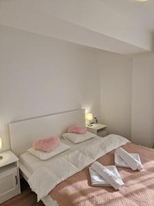 奥托佩尼Star Airport Residence的一间卧室配有带粉红色枕头的床。