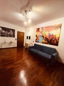 菲乌米奇诺Appartamento tra Aeroporto DaVinci e Fiera di Roma的客厅配有沙发和墙上的绘画