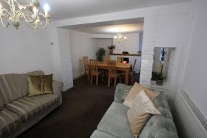 利姆Lymm Cottage的带沙发的客厅和用餐室
