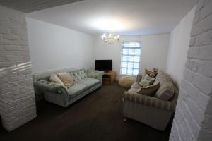 利姆Lymm Cottage的客厅配有两张沙发和一台电视机