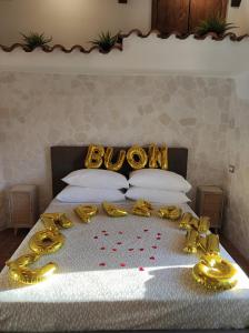 巴罗尼西Setteabbracci Suite & Apartments的一张床上有一大堆金色装饰