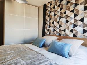 马翁普拉日堡Superbe apt cosy à 500m de la plage pour 4 pers的一间卧室配有一张带两个蓝色枕头的床