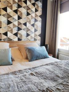 马翁普拉日堡Superbe apt cosy à 500m de la plage pour 4 pers的一间卧室配有带枕头的床铺和墙壁