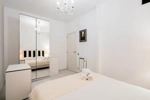马德里Flamenco Style Apartment PALACIO REAL, La Latina的白色卧室配有床和镜子