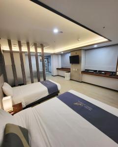 春川Hotel Gongjicheon的酒店客房设有两张床和投影屏幕