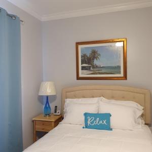 拿骚Ocean Breeze Villa 242的一间卧室配有一张带蓝色枕头的床