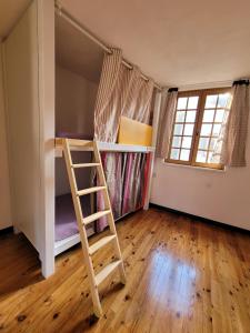 圣让皮耶德波尔Gite de la Porte Saint Jacques: a hostel for pilgrims的带双层床和梯子的客房