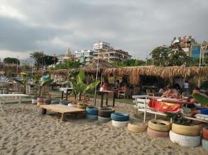 阿拉尼亚Oba Suites Apartmani的沙滩上设有桌椅,人们坐在沙滩上