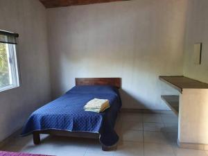 拉佩尼塔德加尔特姆巴C911 Casa 2 niveles y alberca privada的一间卧室配有一张带蓝色棉被的床和窗户。