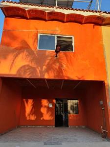 拉佩尼塔德加尔特姆巴C911 Casa 2 niveles y alberca privada的橙色的建筑,有门廊和窗户