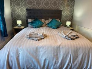 科尔雷恩Glenbann House的一张带两盏灯的带两件长袍的床