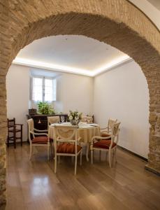 麦地那西多尼亚Hotel Tugasa Casa Palacio Medina Sidonia的一间带拱门和桌椅的用餐室